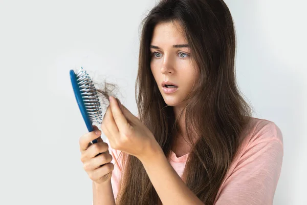 Młoda kobieta jest zdenerwowana z powodu wypadania włosów — Zdjęcie stockowe