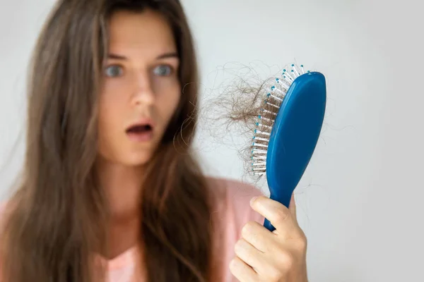 Mujer joven está molesta debido a la pérdida de cabello — Foto de Stock