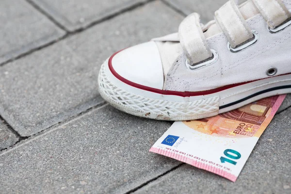 Female foot and ten euro banknote on the ground — Stock Photo, Image