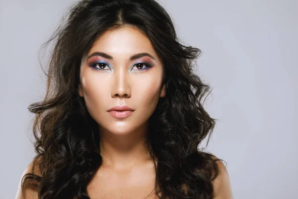 Молодая азиатка с красивыми вьющимися волосами и макияжем — стоковое фото