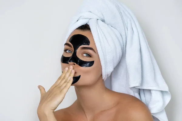 Young and beautiful woman with black peel-off mask on her face — Stock Photo, Image