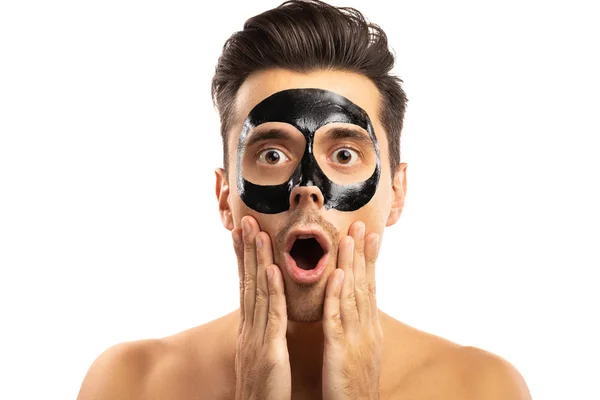 Junger Kerl mit schwarzer Kohlemaske im Gesicht auf weißem Backgr — Stockfoto