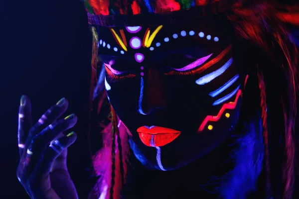 Kvinna med neonmakeup i ultraviolett ljus — Stockfoto