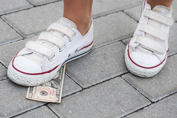 Female foot and ten dollars banknote