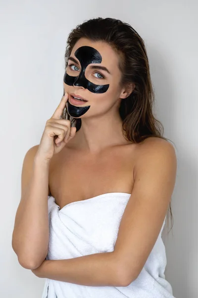 Young and beautiful woman with black peel-off mask on her face — Stock Photo, Image