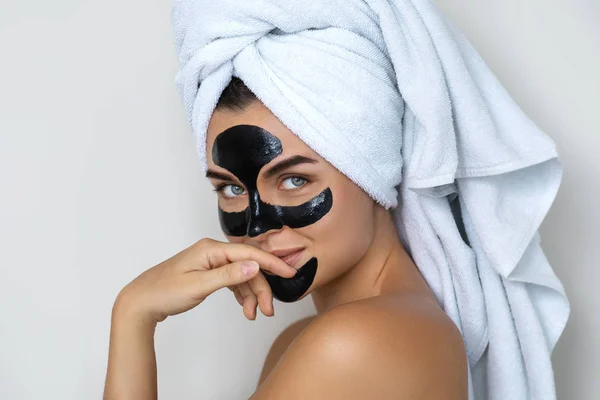 Young and beautiful woman with black peel-off mask on her face — Stock Photo, Image