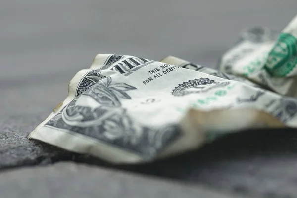 Old and crumpled one dollar bill on the ground — Stock Photo, Image