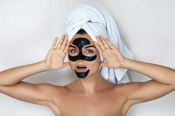 Young and beautiful woman with black peel-off mask on her face — Stock Photo, Image