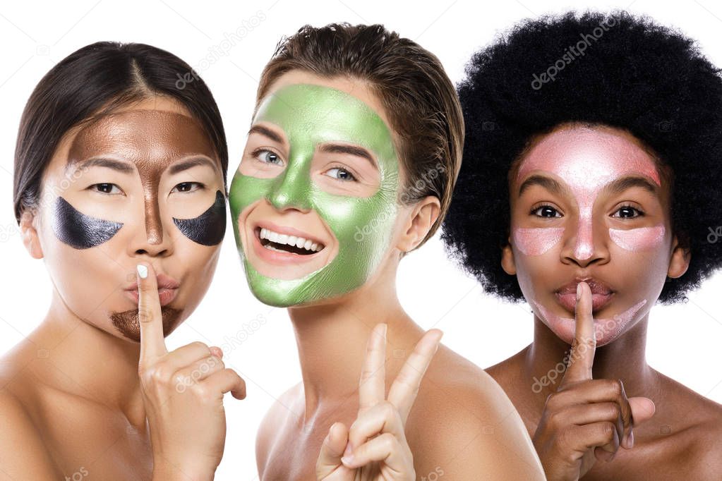 Beautiful multi-ethnic girls with colorful peel-off masks on the