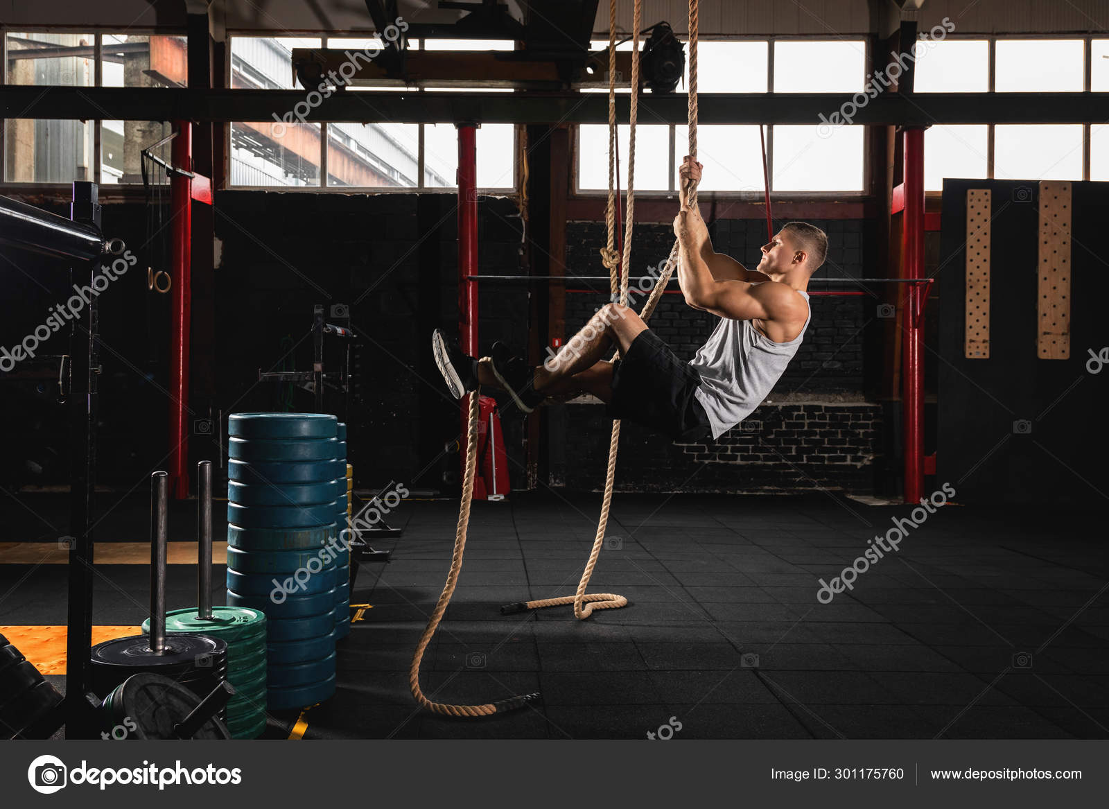 Sportsman doing rope climbing exercise Stock Photo by ©AY_PHOTO