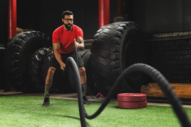 Adam onun çapraz eğitim wo sırasında savaş ipi egzersizleri yapıyor