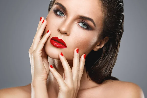 Porträt einer schönen jungen Frau mit rotem Lippenstift und Nagellack — Stockfoto
