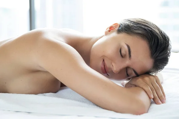 Young and beautiful woman is lying and relaxing after massage — Stock Photo, Image