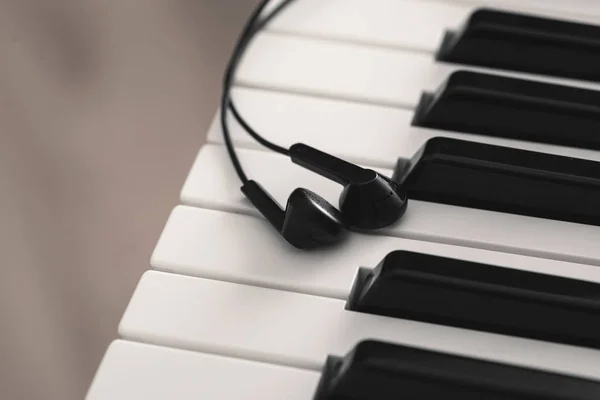 Earphones over piano or synthesizer keyboard