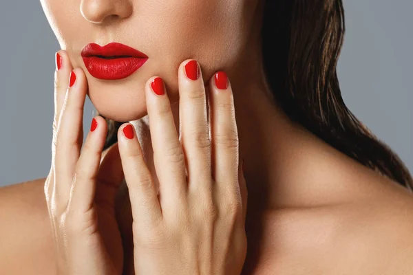 Piękno i kosmetyki. Kobiece usta i paznokcie z czerwonym manicure — Zdjęcie stockowe