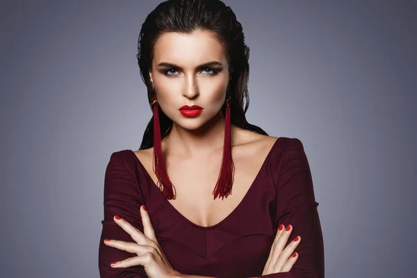 Impresionante mujer con un hermoso maquillaje con pendientes largos de color rojo — Foto de Stock