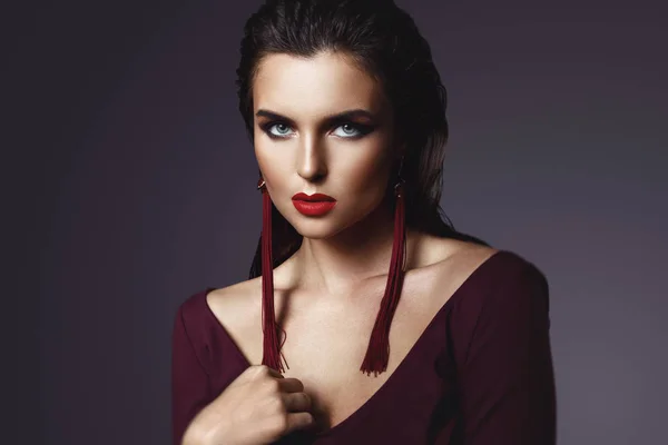 Uzun kırmızı küpe giyen güzel bir makyaj ile Çarpıcı kadın — Stok fotoğraf