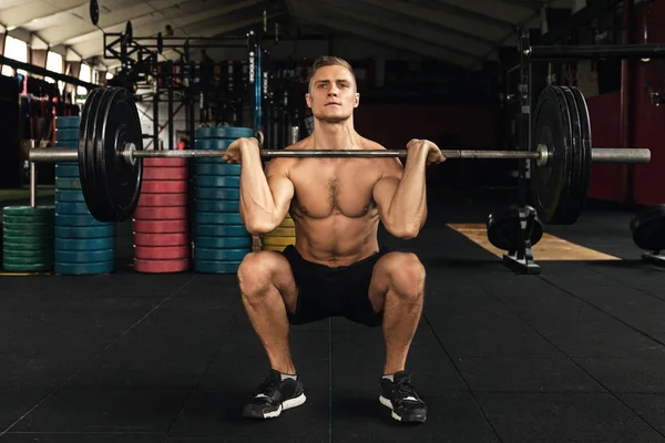 Muskularny Człowiek podczas treningu ciężarowego w siłowni — Zdjęcie stockowe