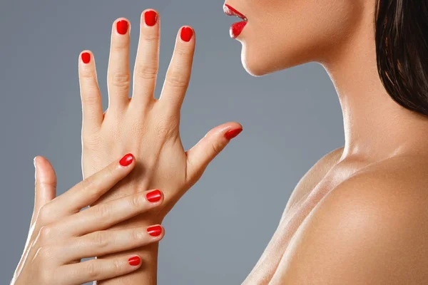 Beauty and cosmetics. Female mouth and nails with red manicure a — Stock Photo, Image