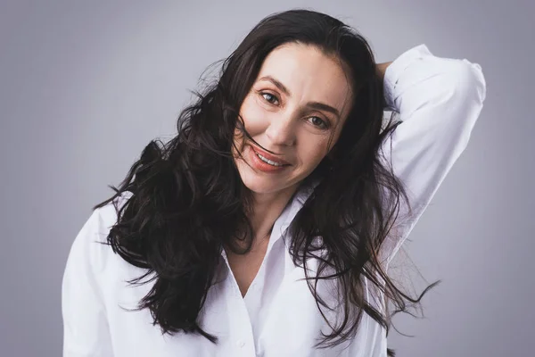 Beautiful middle aged woman wearing white shirt in photo studio — Stock Photo, Image