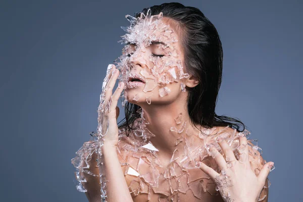 Kvinnlig ansikte täckt med mycket små bitar av glas eller is — Stockfoto