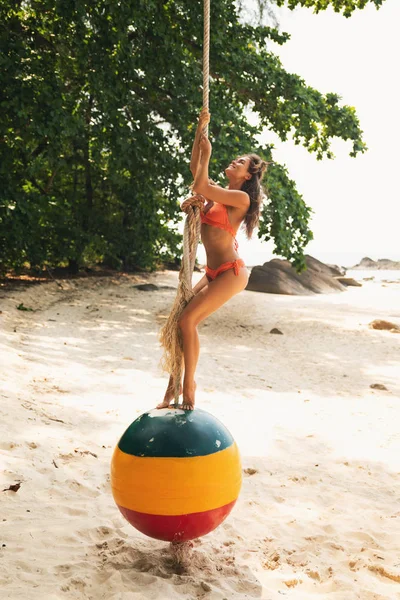 Sahilde eski şamandıra yapılmış salıncaklarda mutlu kadın