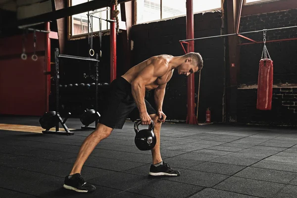 Sportler macht Übungen mit der Kettlebell im Fitnessstudio — Stockfoto