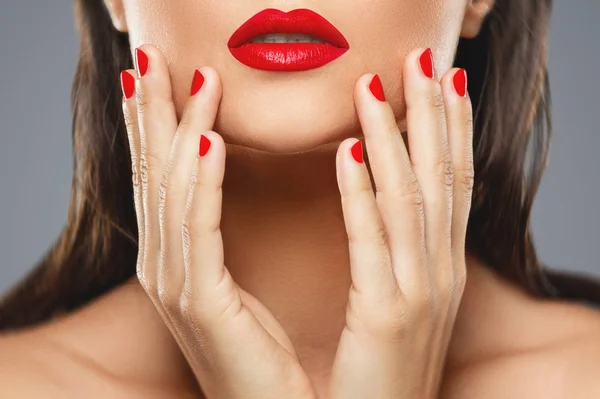 Schoonheid en cosmetica. Vrouwelijke mond en nagels met rode manicure a — Stockfoto