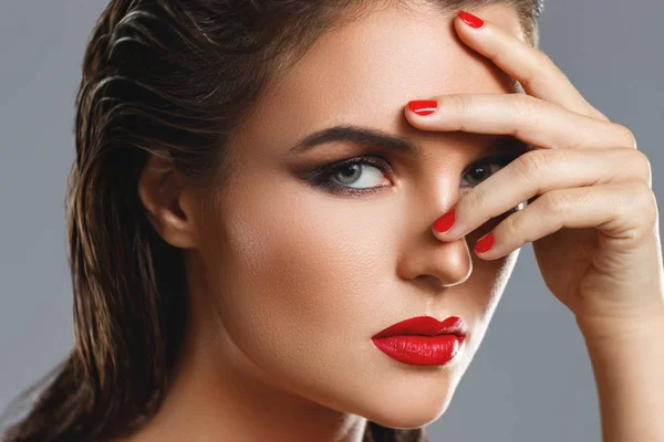 Retrato de una hermosa mujer joven con un lápiz labial rojo y uñas p —  Fotos de Stock
