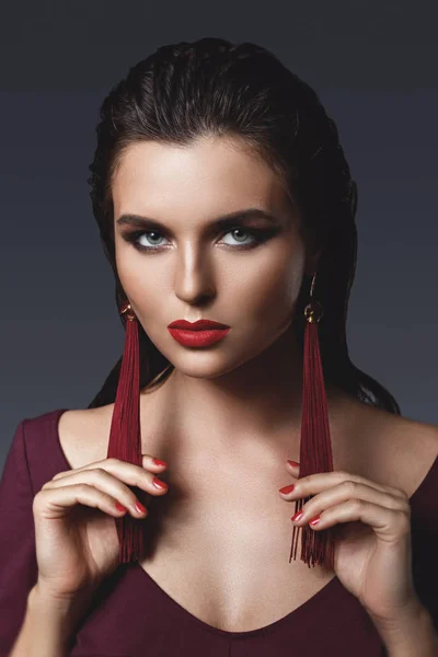Lenyűgöző nő, gyönyörű smink visel, hosszú, piros fülbevaló — Stock Fotó