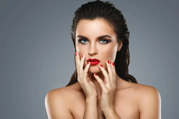 Retrato de una hermosa mujer joven con un lápiz labial rojo y uñas p — Foto de Stock