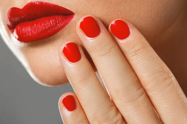 Belleza y cosmética. Boca y uñas femeninas con manicura roja a — Foto de Stock