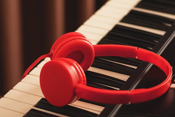 Fones de ouvido vermelhos sobre teclado sintetizador — Fotografia de Stock