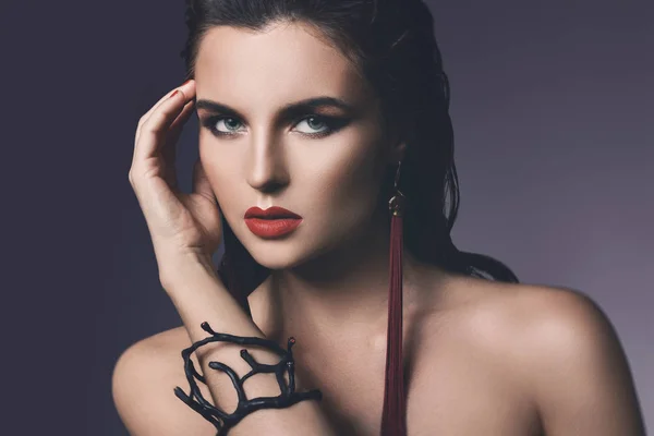Prachtige vrouw met een mooie make-up dragen lange rode oorbellen — Stockfoto