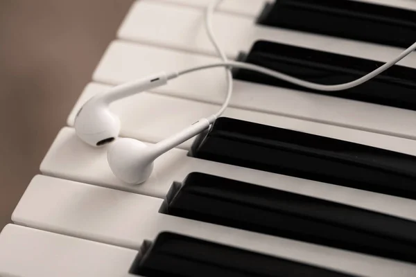 ピアノまたはシンセサイザーキーボード上のイヤホン — ストック写真