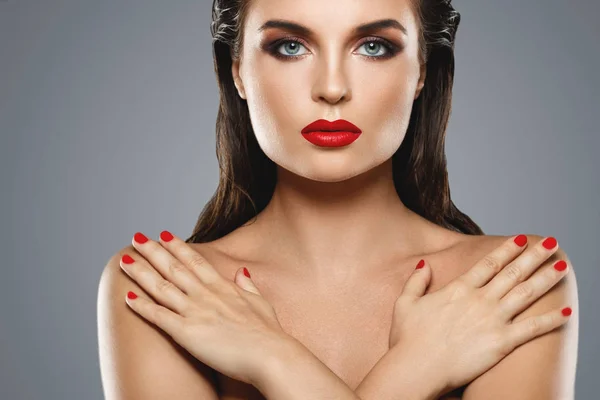Porträt einer schönen jungen Frau mit rotem Lippenstift und Nagellack — Stockfoto