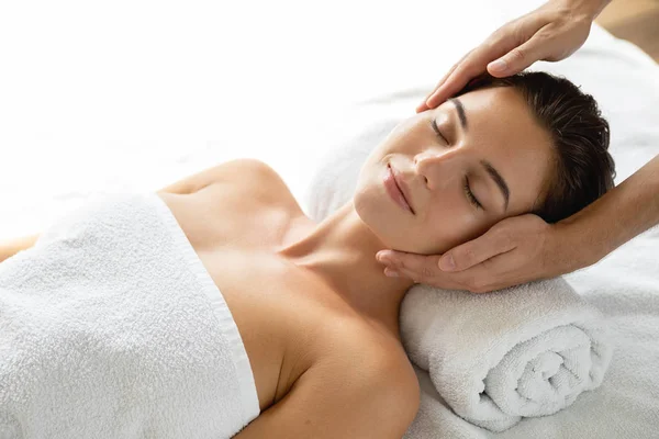 Mujer joven y hermosa durante la sesión de masaje facial —  Fotos de Stock