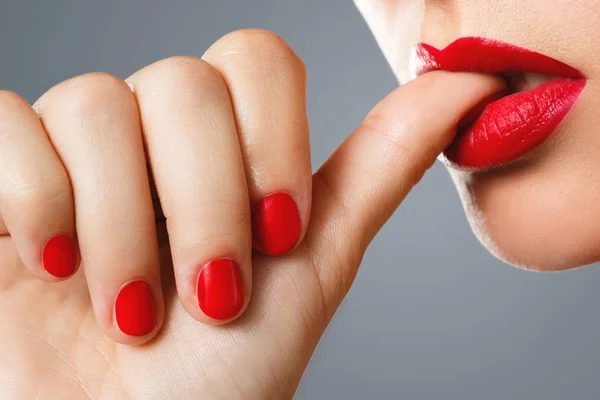 Beauty and cosmetics. Female mouth and nails with red manicure a — Stock Photo, Image