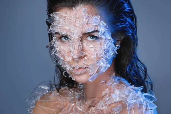 Visage féminin recouvert de beaucoup de petits morceaux de verre ou de glace — Photo