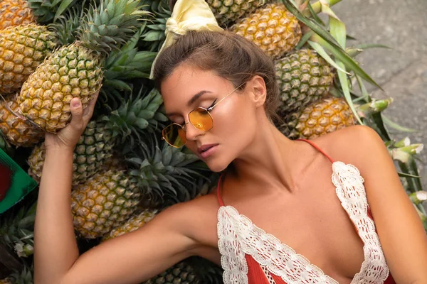 Yerel Tha üzerinde ananas yığını ile genç ve mutlu kadın
