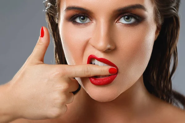 Retrato de una hermosa mujer joven con un lápiz labial rojo y uñas p — Foto de Stock