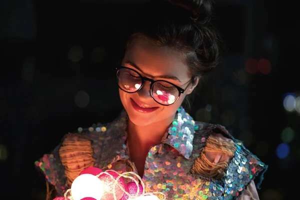 Szczęśliwa kobieta ubrana w świecącą kurtkę z cekinami trzyma światło — Zdjęcie stockowe
