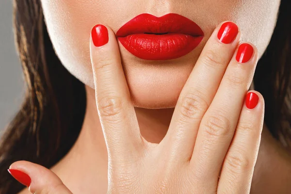 Schoonheid en cosmetica. Vrouwelijke mond en nagels met rode manicure a — Stockfoto