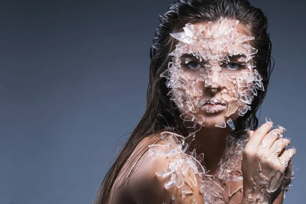 Frauengesicht mit vielen kleinen Glas- oder Eisstücken bedeckt — Stockfoto