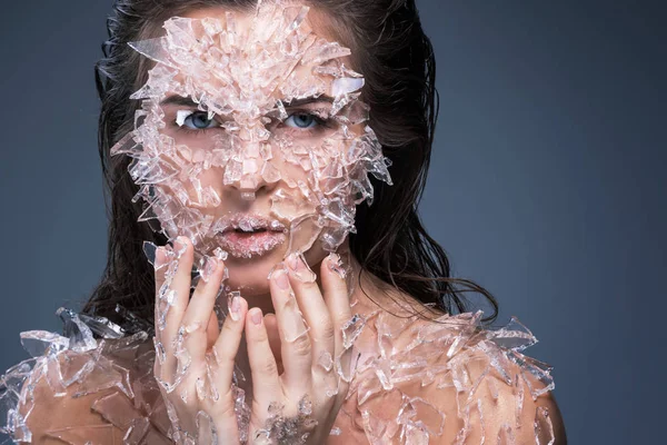 Kvinnlig ansikte täckt med mycket små bitar av glas eller is — Stockfoto