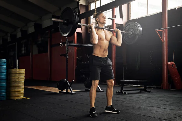 Muskulöser Mann beim Gewichtheben im Fitnessstudio — Stockfoto