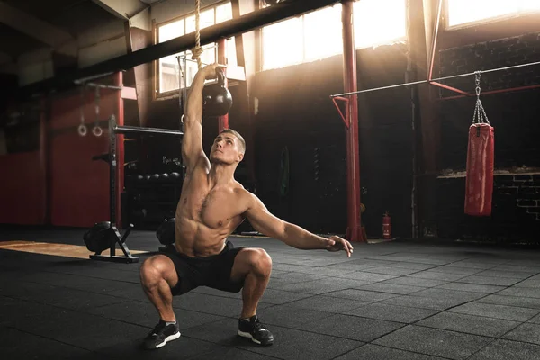 Sportler macht Übungen mit der Kettlebell im Fitnessstudio — Stockfoto