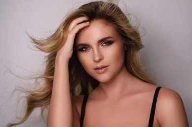 Güzel kıvırcık saçlı ve profesyonel makyajlı muhteşem bir kadının portresi.