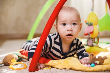 Küçük şirin bebek paspasın üstünde oynuyor. 