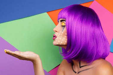 Renkli arka planda pop sanat makyajlı yaratıcı bir model